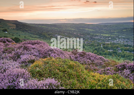 Ciel coucher de soleil orange et haute sur Scenic Ilkley Moor (lande de bruyère pourpre) dans la ville nichée dans la vallée - Ilkley, Wharfedale, Yorkshire, FR, UK Banque D'Images