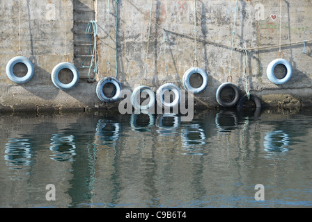 Les pneus de voiture utilisés comme offres pour les bateaux dans le port de pêche de Hasle sur la côte nord-ouest de l'île de Bornholm en mer Baltique Banque D'Images