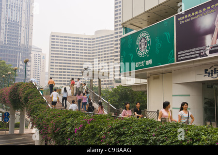 GUANGZHOU, province de Guangdong, Chine - Les piétons devant Starbucks enseigne publicitaire dans la ville de Guangzhou. Banque D'Images