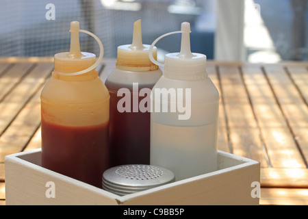 Sauce tomate, vinaigre blanc et rouge - bouteilles et de sel sur la table au restaurant de fruits de mer à Kalk Bay Harbour, près de Cape Town. Banque D'Images