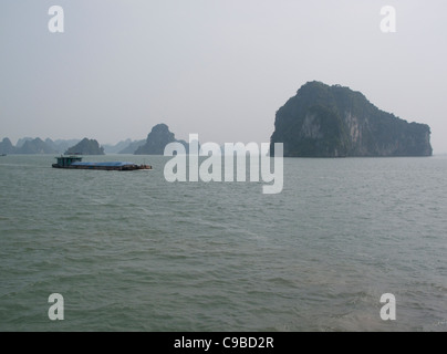 Cargo passant la baie d'Halong rock formations en mer de Chine du Sud, Vietnam Banque D'Images