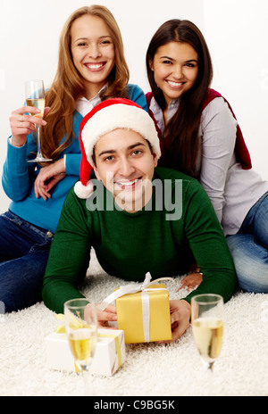 Image de tenage amis avec champagne et cadeaux looking at camera Banque D'Images