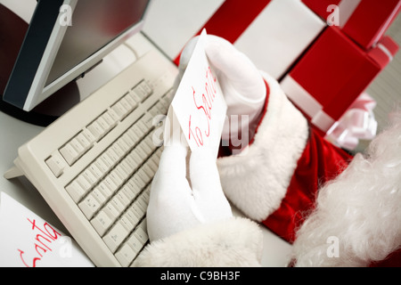 Close-up of Santa les mains gantées tenant lettre avec remarque "à Santa' Banque D'Images