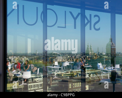 Les personnes et les bâtiments reflètent dans les fenêtres de toit-terrasse le Skylounge bar à Amsterdam aux Pays-Bas Banque D'Images