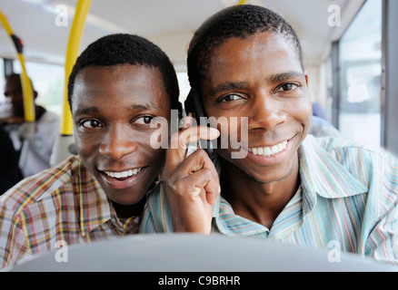 Boy Friend sur le bus, à l'écoute de téléphone mobile, Cape Town, Western Cape Province, Afrique du Sud Banque D'Images