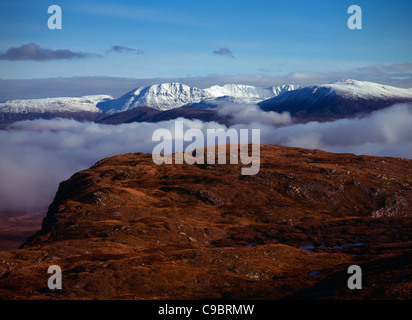 L'Écosse, Highlands, à l'Ouest, Ben Plus de forêt et montagnes couvertes de neige blanc épais Assynt au-dessus des nuages Banque D'Images