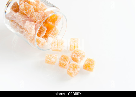 Cubes de gingembre confit s'échappant d'un pot de rangement en verre Banque D'Images