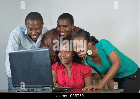 Les étudiants kenyans réunis autour d'un ordinateur portable, Nairobi, Kenya Banque D'Images