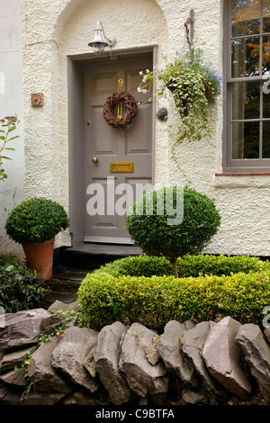 Porte d'entrée à un cottage anglais,avec mur d'ardoise à sec ,suspension ,topiaire , porte en bois et fenêtre à guillotine,angleterre. Banque D'Images