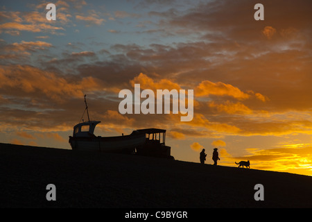 Bateau de pêche et les marcheurs au coucher du soleil Plage Weybourne UK Octobre Banque D'Images