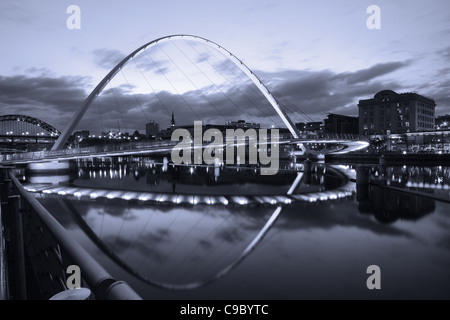 Le Gateshead Millennium Bridge prises pendant le crépuscule avec des lumières reflétées dans la rivière Tyne. Banque D'Images