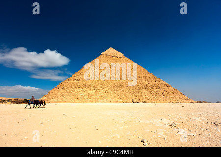 Un homme sur un cheval à travers le désert au-delà de la pyramide de Gizeh à l'Khafré Neropolis Banque D'Images