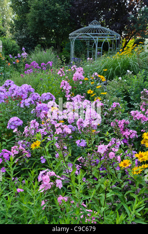 Jardin phlox (phlox paniculata) et false (tournesol Heliopsis helianthoides) en face d'un pavillon de jardin. design : Marianne et detlef lüdke Banque D'Images