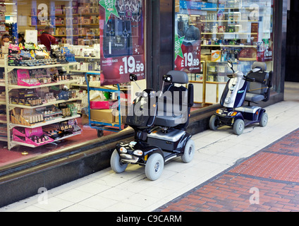 Deux véhicules de mobilité à l'extérieur d'un magasin à Eastbourne Banque D'Images