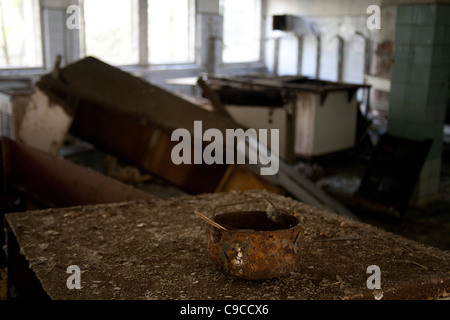 Pot rouillé sur une table rouillée dans la cuisine de l'école intermédiaire Pripyat Pripyat Zone d'exclusion de Tchernobyl l'Ukraine Banque D'Images