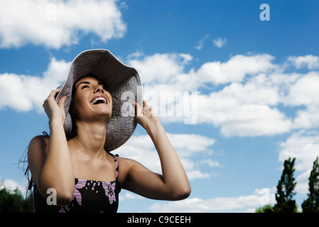 Jeune femme portant chapeau de soleil, rire Banque D'Images