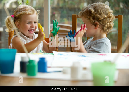 Les enfants la peinture au doigt, les mains couvertes de peinture Banque D'Images