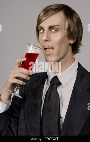 Beau jeune vampire sous forme de boisson en verre Champaign Banque D'Images