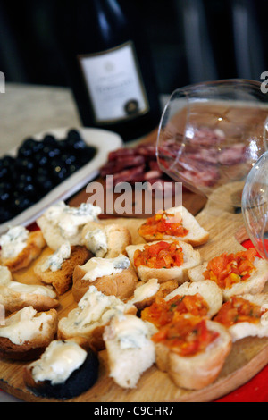 Assiette de fromage, salami, des olives et du vin à l'Osteria Da Lio, La Maddalena, en Sardaigne, Italie. Banque D'Images