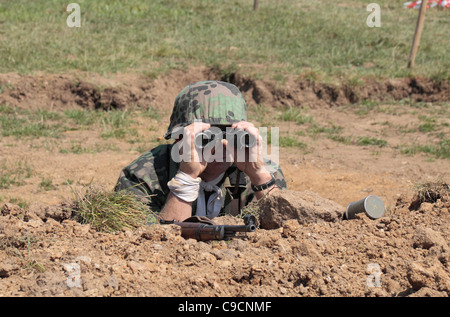 La reconstitution médiévale une tenue de camouflage à l'aide de jumelles à la guerre de 2011 et à la paix, Hop Farm Paddock Wood, Kent, UK. Banque D'Images