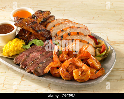 Crevettes, poulet, boeuf et porc fajitas au bœuf servi sur les légumes Banque D'Images