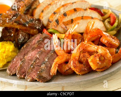 Crevettes, steak, poulet et côtes de porc sur les légumes fajitas Banque D'Images
