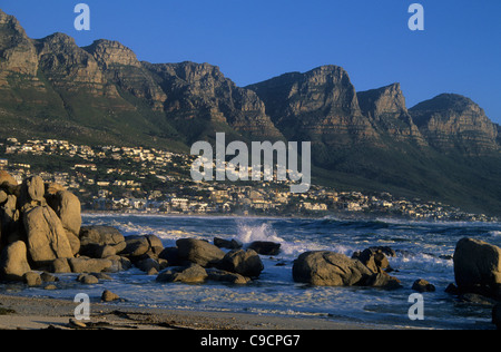 Les vagues de l'Atlantique au cours de l'écrasement des pierres à Camps Bay, près de Cape Town, avec table mountain en arrière-plan, le Cap, Afrique du Sud. Banque D'Images