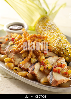 Fajitas au poulet garni de légumes sur la salsa et d'oignons avec un épi de maïs grillé Banque D'Images