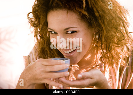 Portrait of a young woman drinking from un espresso cup Banque D'Images