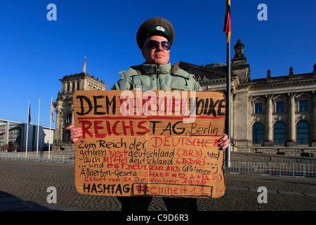 Un homme est titulaire d'un écriteau exigeant des droits historiques pour les régions d'Allemagne de l'est, devant le siège du Parlement fédéral allemand Reichstag bâtiment du Bundestag à Berlin Banque D'Images