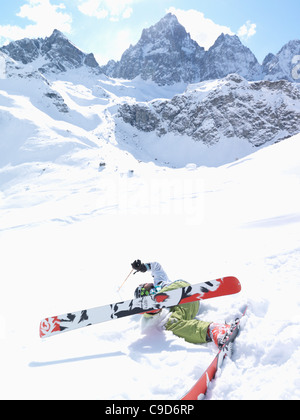 L'Italie, Piémont, Teenage boy tomber tout en bas de la pente de ski de montagne Banque D'Images