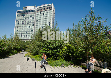 USA, New York, Manhattan, côté ouest, le parc High Line, les gens se détendre sur des bancs autour de la 13e rue à l'hôtel standard au-delà. Banque D'Images