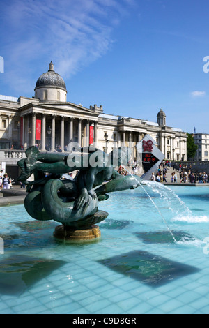 Tritons et fontaine du Dauphin avec l'horloge du compte à rebours numérique olympique et la National Gallery à Trafalgar Square, Londres, UK Banque D'Images