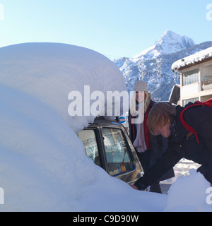 L'Italie, Piémont, Bardonecchia, adolescent et sa mère entrer car enterré sous la neige Banque D'Images