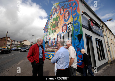 Le Sinn Fein, Martin McGuinness parlant à part ses collègues à côté d'une sculpture commémorant le 1981 grève de la faim. Banque D'Images