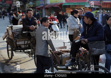 Les travailleurs migrants de prendre une pause de la collecte de recyclage de matériaux pour socialiser, Shanghai, Chine, Asie Banque D'Images