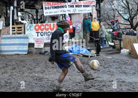 Le 23 novembre 2011, la Police de Toronto en nombres significatifs déployés au cours de l'aube des heures ce matin, à commencer le processus d'expulsion du camp de tentes de Toronto occupent de St James Park. Ici peu après l'aube, une protestation non identifié dispose de ses compétences de football par la bande du parc shell. Banque D'Images