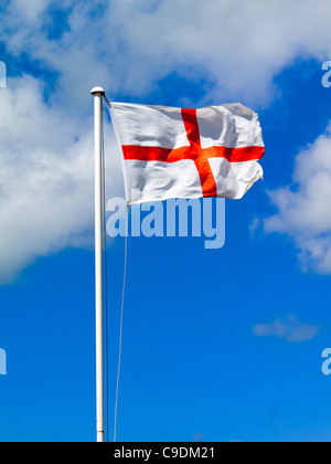 Drapeau anglais connu sous le nom de St George's Cross battant avec ciel bleu derrière représente également les armes de la plus noble Ordre de la jarretière Banque D'Images