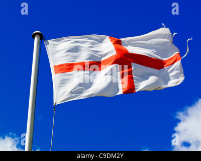 Drapeau anglais connu sous le nom de St George's Cross battant avec ciel bleu derrière représente également les armes de la plus noble Ordre de la jarretière Banque D'Images