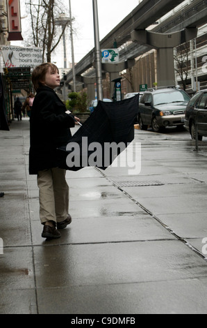 Garçon avec parapluie dans la ville Banque D'Images