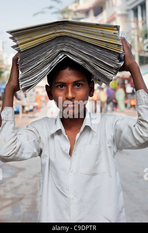 Papier indien garçon avec des papiers sur sa tête. L'Andhra Pradesh, Inde Banque D'Images