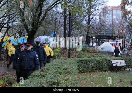 Novembre 23, 2011, Toronto Police déployée en nombre significatif tôt ce matin pour commencer l'éviction du camp de tentes de Toronto occupent de St James Park. Ici la police et les travailleurs municipaux de peigner la site. Banque D'Images