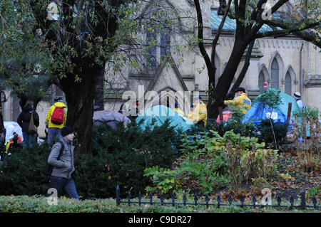 Novembre 23, 2011, Toronto Police déployée en nombre significatif tôt ce matin pour commencer l'éviction du camp de tentes de Toronto occupent de St James Park. Ici la police et les travailleurs municipaux de peigner la site. Banque D'Images