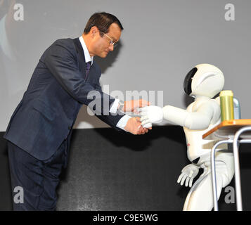 30 novembre 2011, Tokyo, Japon - Takanobu Ito, président de Honda, est attendu avec une tasse de thé par Ashimo, en forme humaine développé par le constructeur du robot, au cours d'une conférence de presse aperçu de la Tokyo Motor Show le mercredi, Novembre 30, 2011...le Tokyo Motor Show a ouvert ses portes à la presse mercredi que le japonais Banque D'Images