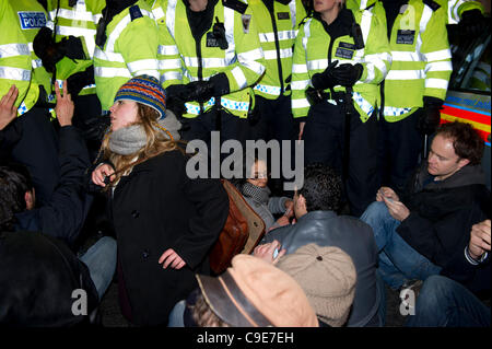 30Th Nov 2011, Haymarket, Londres. Les manifestants tentent de bloquer la route pour empêcher un véhicule de police en laissant contenant les prisonniers qui ont été arrêtés pendant la brève occupation de Panton House à Londres. Asseoir la protestation a été brève et la police sur les manifestants déplacé rapidement. Banque D'Images