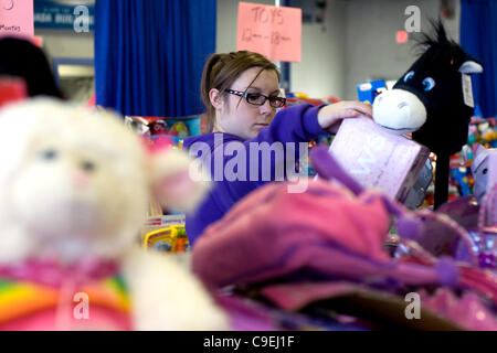 London, Ontario, Canada - le 8 décembre 2011. Katie Hart choisit, de dons de jouets qui seront inclus dans les paniers de jouets de Noël 2011 à l'Armée du salut et de jouets de nourriture Distribution center à l'intérieur de la construction au Western Fair District. Cette année, l'Armée du Salut s'attend à fournir Banque D'Images