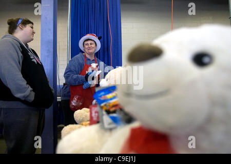 London, Ontario, Canada - le 8 décembre 2011. Kaii Forbes, gauche et Kelley Thompson examiner certains jouets avant qu'ils emballés dans des paniers de jouets de Noël 2011 à l'Armée du salut et de jouets de nourriture Distribution center à l'intérieur de la construction au Western Fair District. Cette année, le bras du Salut Banque D'Images