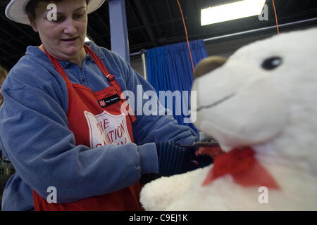 London, Ontario, Canada - le 8 décembre 2011. Kelley Thompson inspecte les jouets avant qu'ils sont emballés dans des paniers de jouets de Noël 2011 à l'Armée du salut et de jouets de nourriture Distribution center à l'intérieur de la construction au Western Fair District. Cette année, l'Armée du Salut s'attend à fournir de la nourriture Banque D'Images