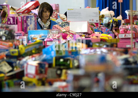 London, Ontario, Canada - le 8 décembre 2011. Lynn Dryburgh sorte via les tables des dons de jouets à l'Armée du Salut 2011 toy et centre de distribution de nourriture à l'intérieur de la construction au Western Fair District. Cette année, l'Armée du Salut s'attend à fournir de la nourriture et des paniers de jouets plus Banque D'Images