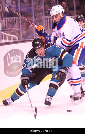 Décembre 17, 2011 - San Jose, Californie, États-Unis - Les requins aile gauche Brad Winchester (10) protège la rondelle du défenseur des Oilers Theo Peckham (24) au cours de la partie de la LNH entre les Sharks de San Jose et les Oilers d'Edmonton chez HP Pavilion de San Jose, CA. Les équipes sont à égalité après la première période. (Crédit Imag Banque D'Images